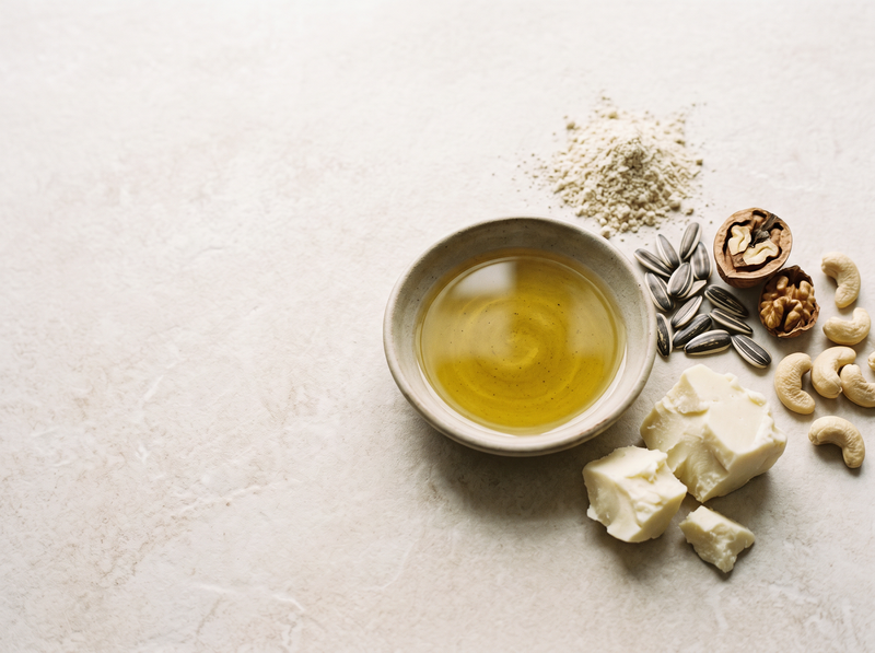 Plant oil in a bowl with sunflower seeds, walnuts, cashews, flour and pieces of fat